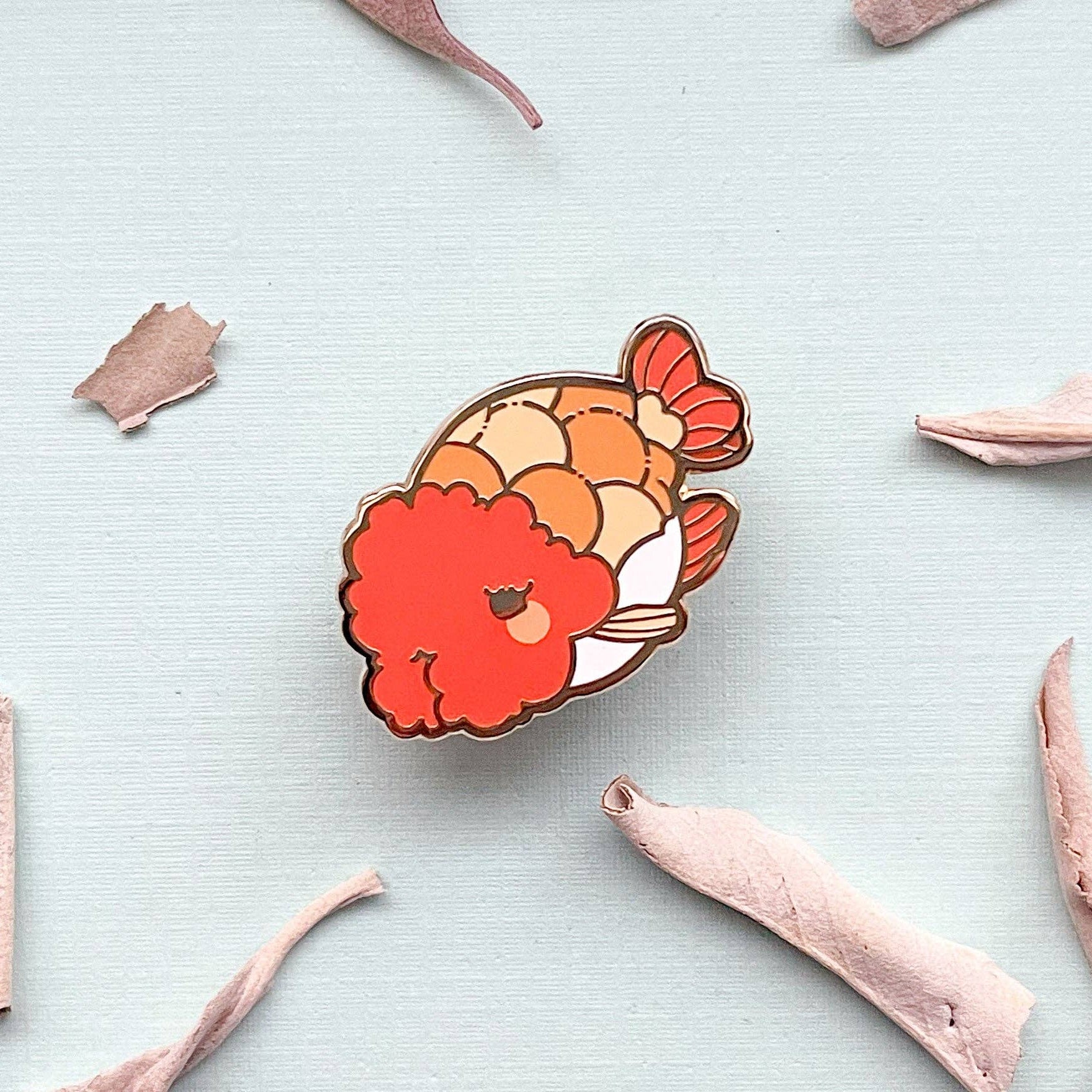 Ranchu Goldfish pin on a light gray background with dried sage leaves
