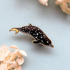 Dolphin-shaped pin on a light blue background with flowers