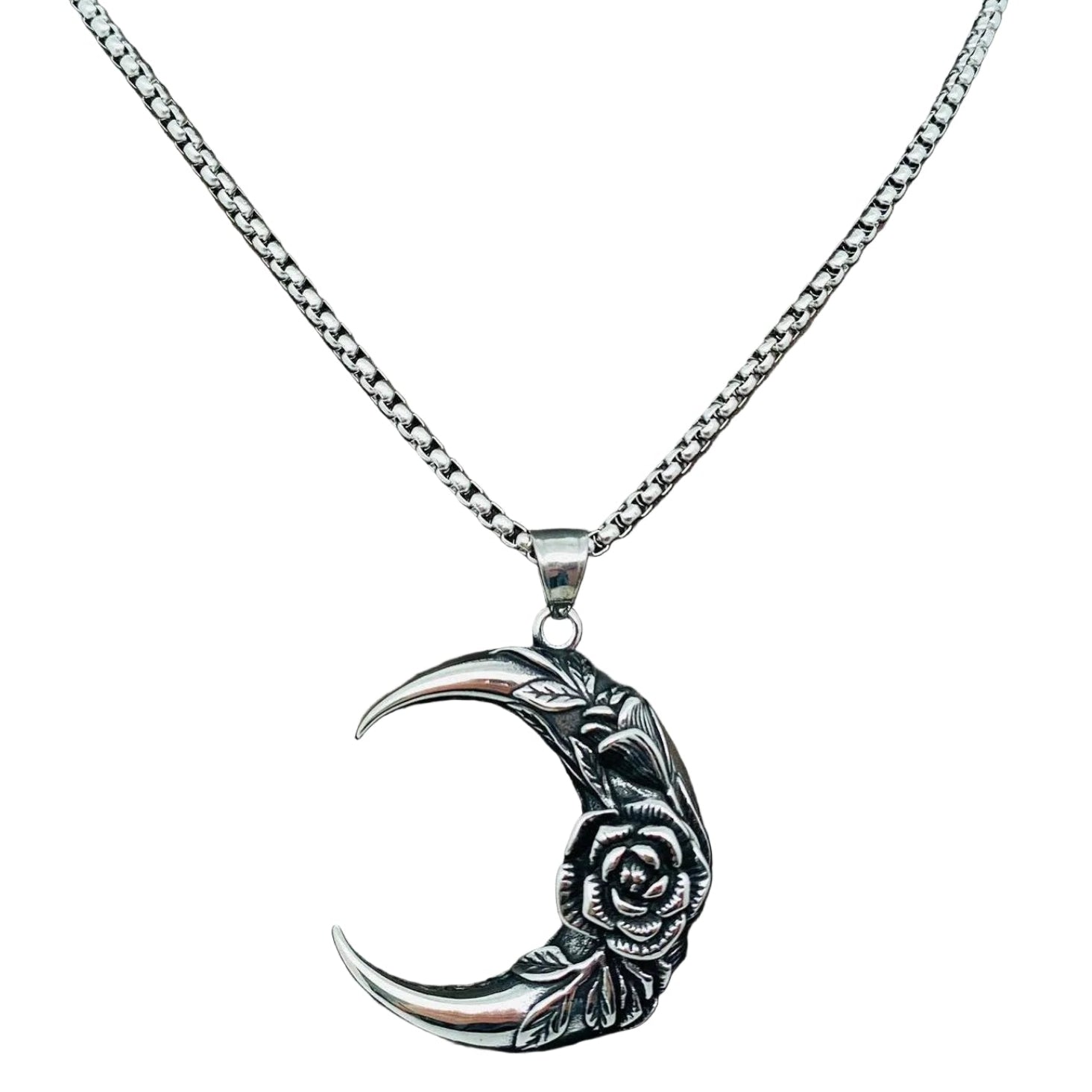 Silver necklace with a crescent moon and rose pendant on a mannequin.