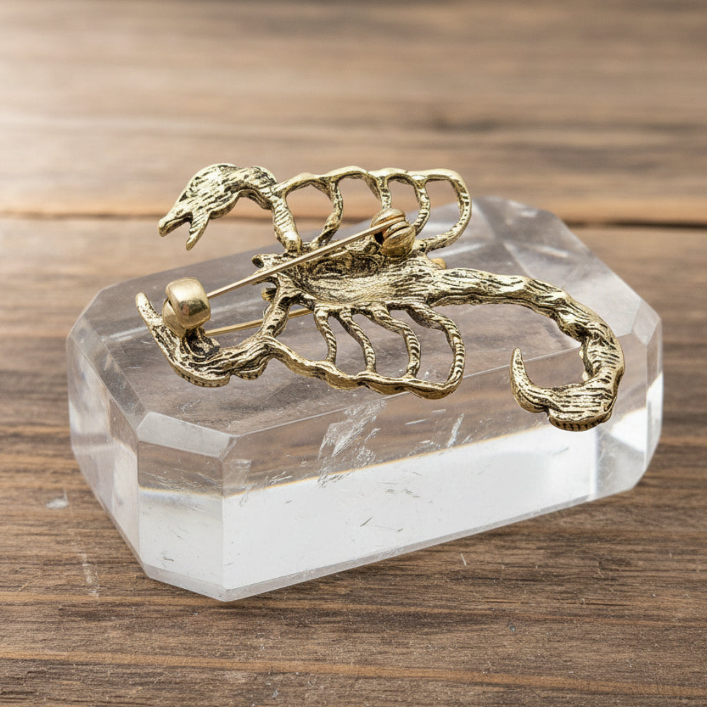 Gold scorpion-shaped brooch on a crystal quartz surface
