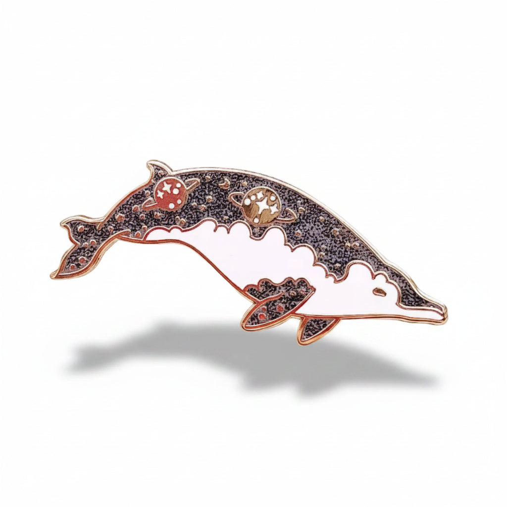 Decorative dolphin brooch with gemstones on a light background