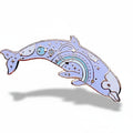 Decorative dolphin pin with celestial design on a white background