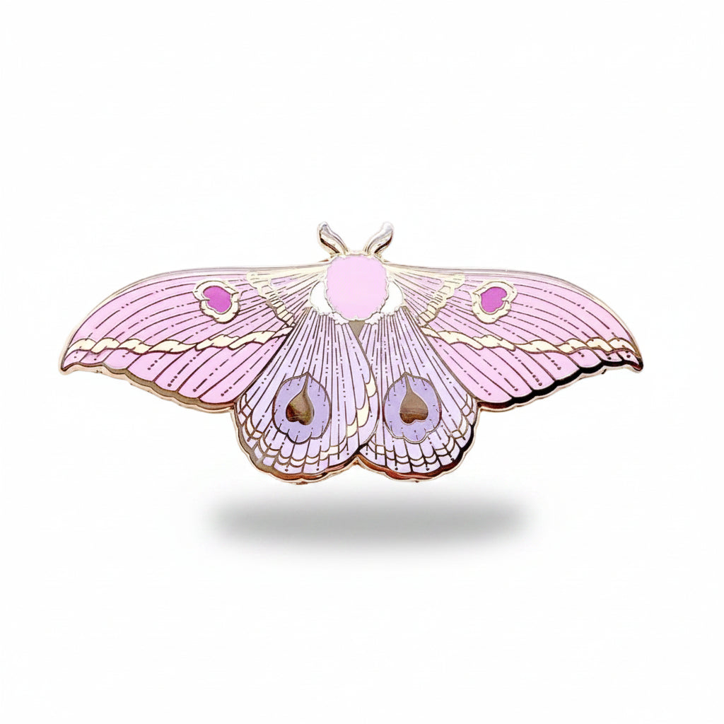 Pink moth-shaped enamel pin on a light background