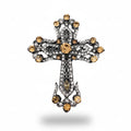 Decorative cross brooch with gemstones on a gray textured background