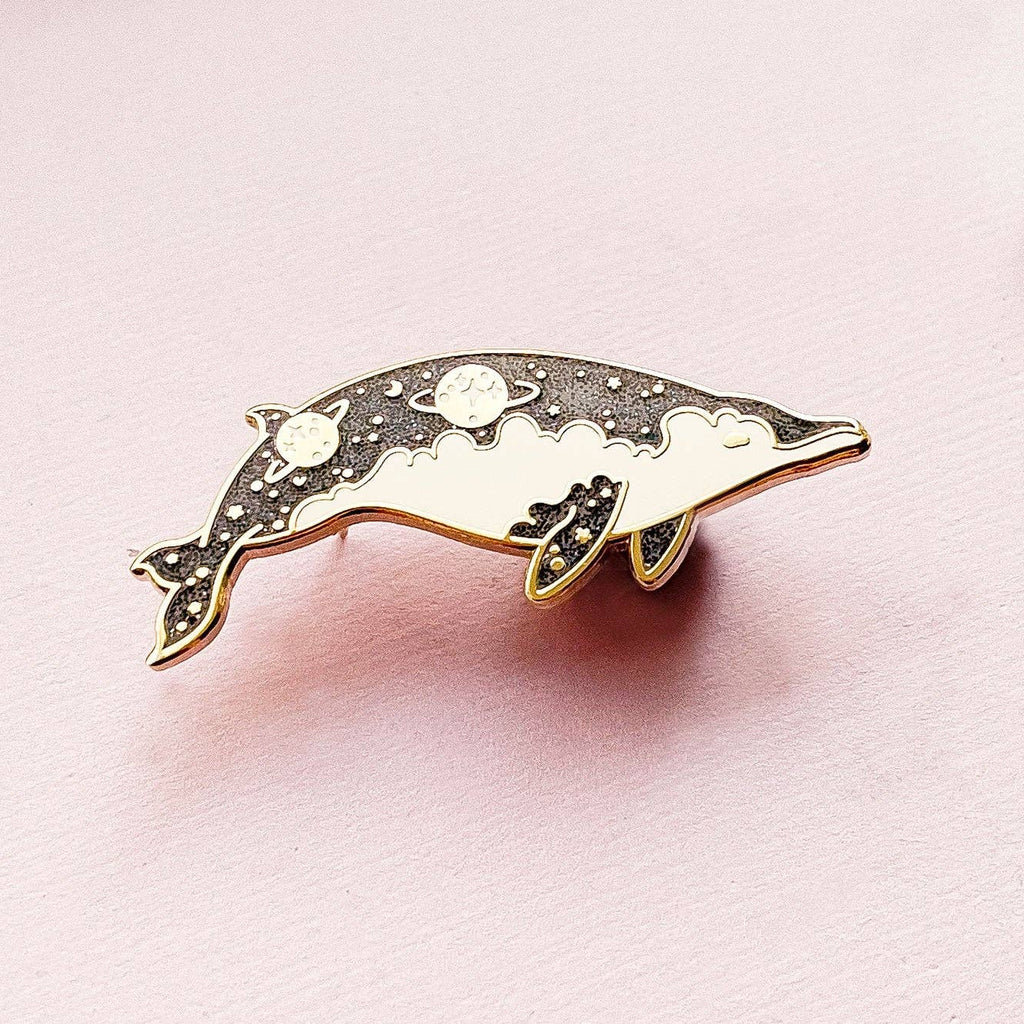 Dolphin-shaped pin on a pink background