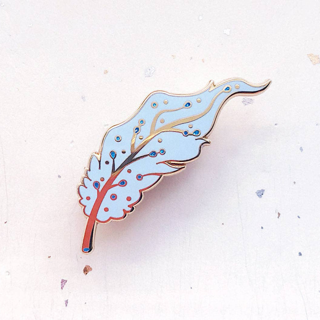 Decorative leaf-shaped pin on a light background
