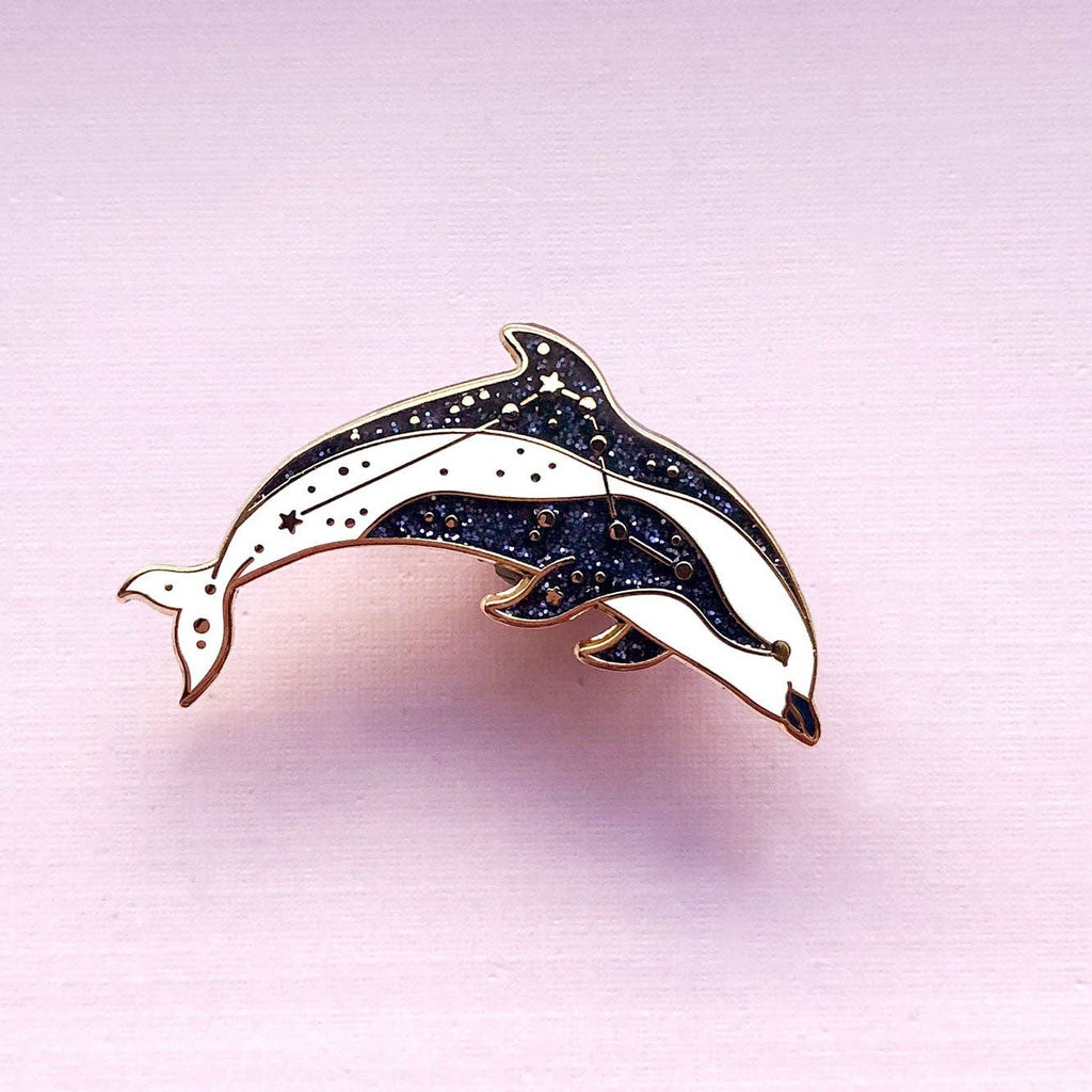 Dolphin-shaped brooch on a pink background