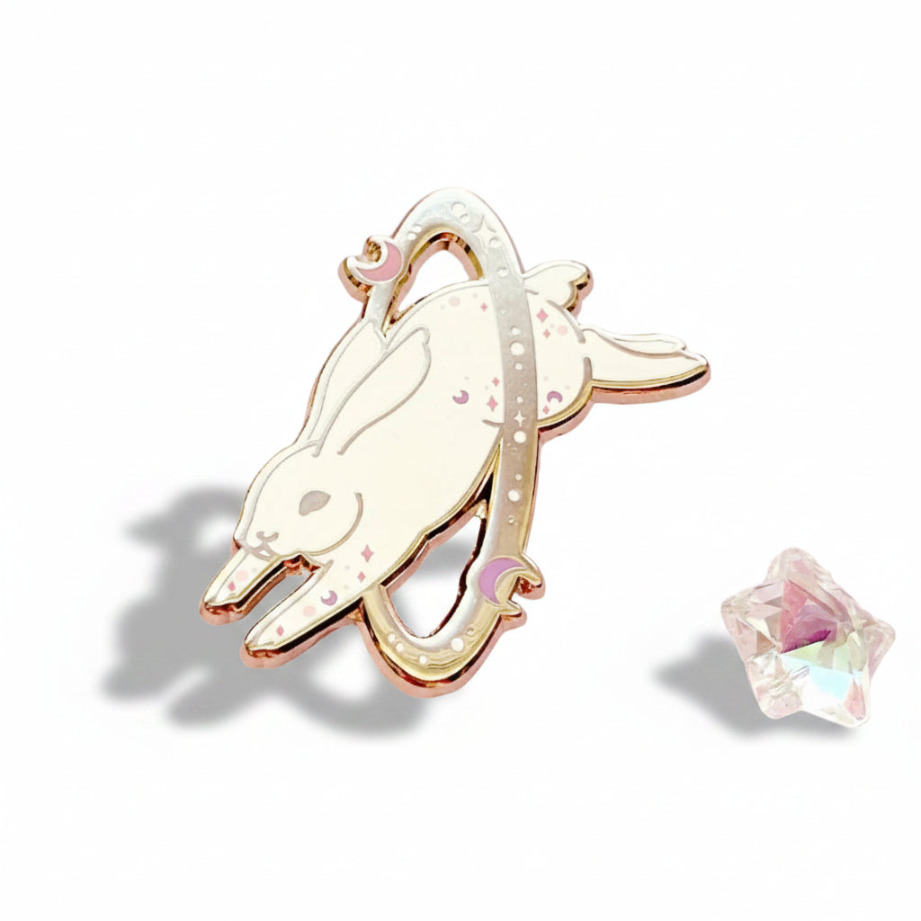 cosmic white rabbit enamel pin with rhinestones on a pink background