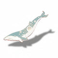 Decorative whale pin on a pink background with seashells