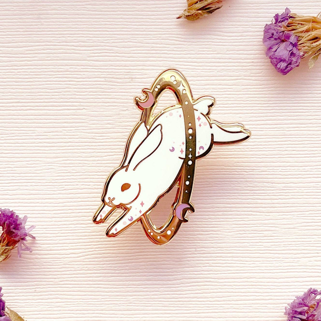 Decorative bunny-shaped object on a textured surface with dried flowers