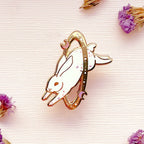 Decorative bunny-shaped object on a textured surface with dried flowers