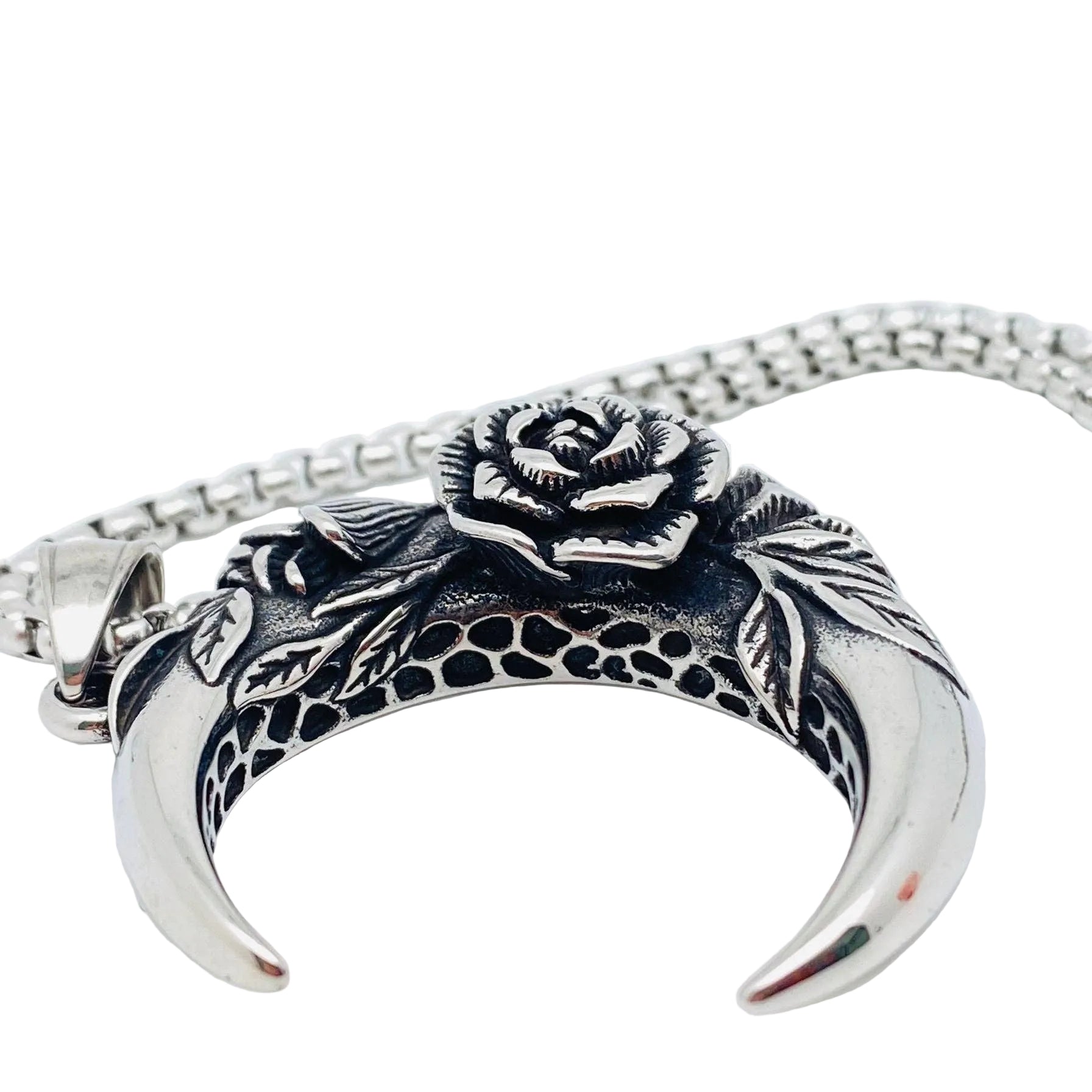 Silver necklace with a crescent moon and rose design on a white background