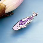 Decorative whale-shaped pin on a light blue background
