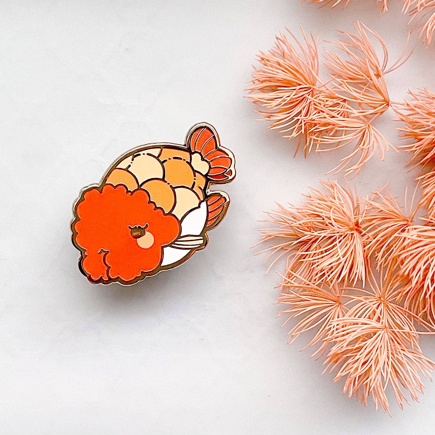 Ranchu Goldfish enamel pin on a white background with pink decorative elements